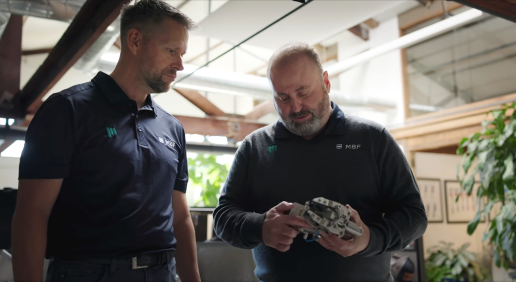 ProMach MBF technicians examining precision packaging automation tooling